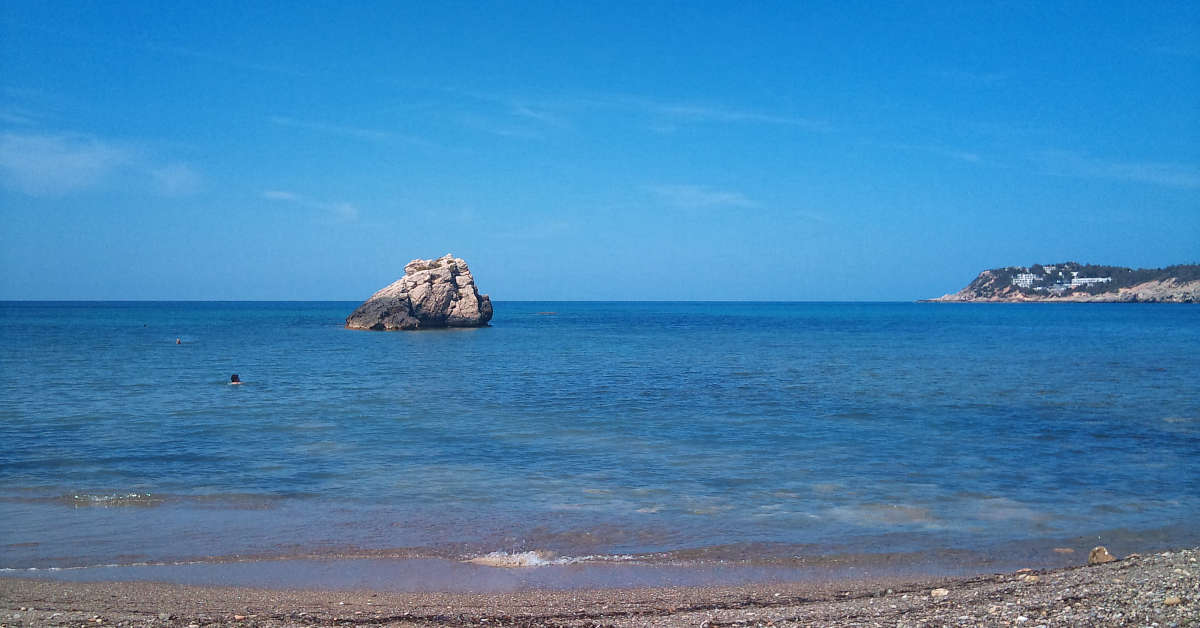 The beach of Cala Xarraca in Ibiza with a charter boat